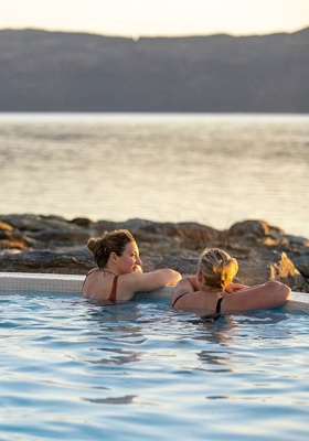 Two people enjoying an outdoor spa pool at Portavadie Spa